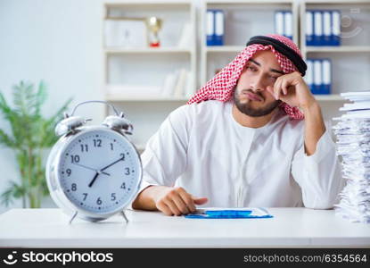 Arab businessman working in the office doing paperwork with a pi. Arab businessman working in the office doing paperwork with a pile of papers