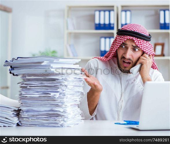 Arab businessman working in the office doing paperwork with a pile of papers. Arab businessman working in the office doing paperwork with a pi