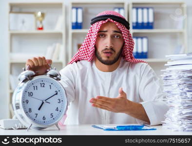 Arab businessman working in the office doing paperwork with a pile of papers. Arab businessman working in the office doing paperwork with a pi