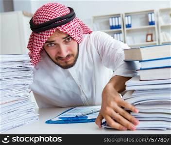 Arab businessman working in the office doing paperwork with a pile of papers. Arab businessman working in the office doing paperwork with a pi