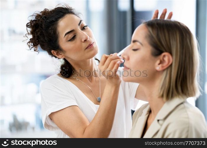 Arab makeup artist making up a woman in a beauty center. Beauty and Aesthetic concepts.. Arab makeup artist making up a woman in a beauty center.