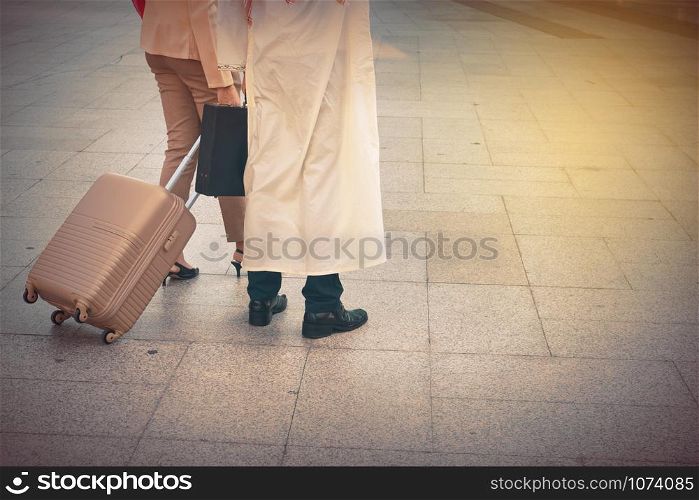 Arab man and woman walking carrying a suitcase