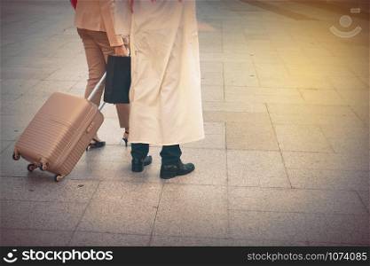 Arab man and woman walking carrying a suitcase
