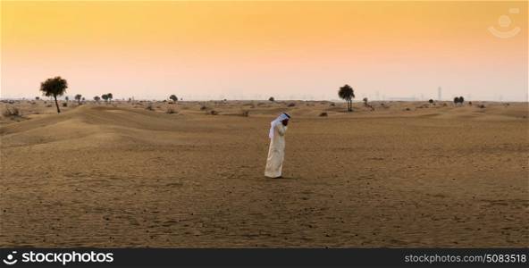 Arab man in the desert at sunset