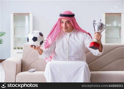 Arab man watching sport football at tv