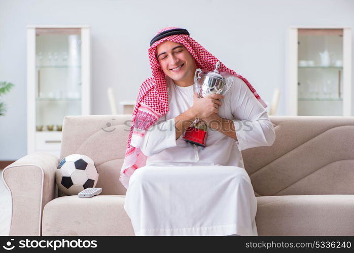 Arab man watching sport football at tv