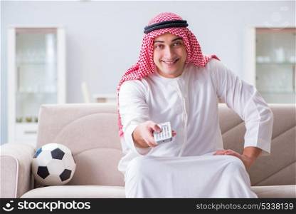 Arab man watching sport football at tv