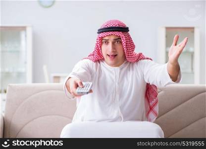 Arab man watching tv at home