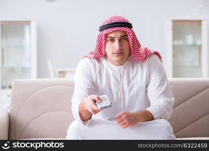 Arab man watching tv at home