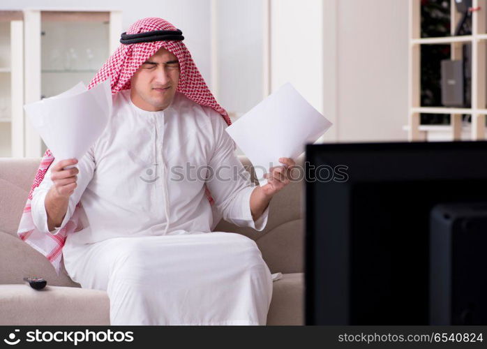 Arab man watching tv at home