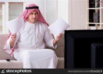 Arab man watching tv at home