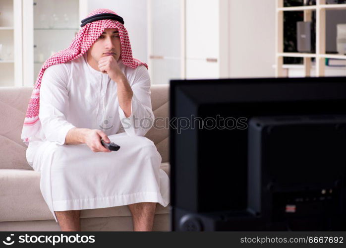 Arab man watching tv at home