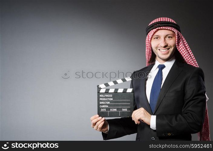 Arab man with movie clapper isolated on white