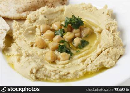 Arab masbacha, hummus dip served with whole chickpeas and a chilli and lemon flavoured sauce and unleavened bread.