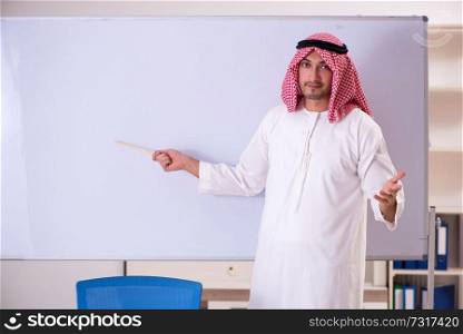 Arab teacher in front of whiteboard 