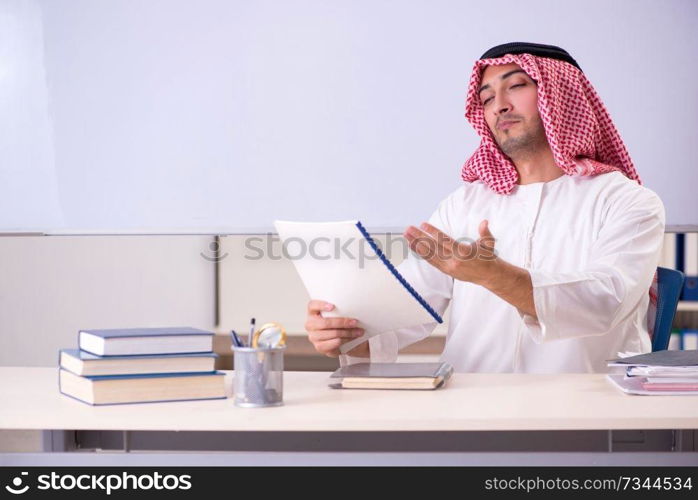 Arab teacher in front of whiteboard 