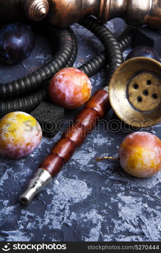 arabian hookah on plums. Turkish smoking shisha with the aroma of autumn plum