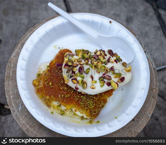 Arabic dessert Kunafa made with cheese and honey and pistache with ice cream