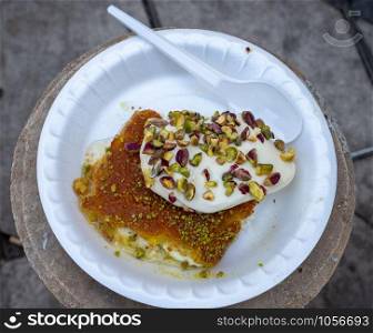 Arabic dessert Kunafa made with cheese and honey and pistache with ice cream