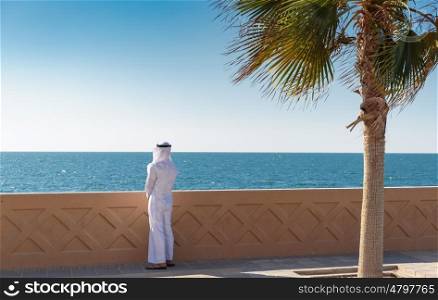 Arabic man is on the waterfront and looking at the sea