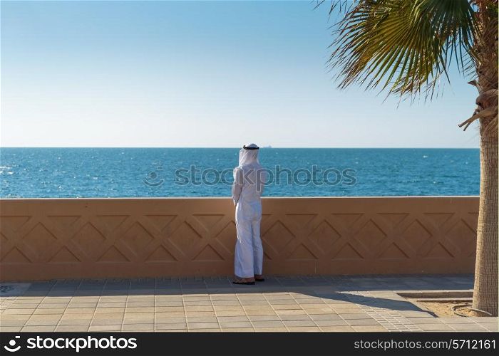 Arabic man is on the waterfront and looking at the sea