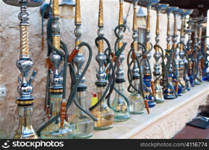 Arabic shisha, sometimes caled hookah, waterpipes lined up on a bar for customers in a restaurant in an Arabic country.