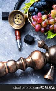 Arabic smoking hookah with grapes. Exotic smoked shisha with tobacco with a taste of grapes