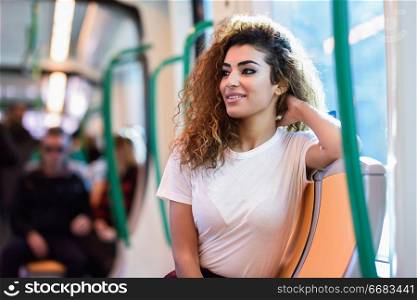 Arabic woman inside subway train. Arab girl in casual clothes near a window.. Arabic woman inside subway train. Arab girl in casual clothes.