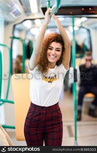 Arabic woman inside subway train. Arab girl in casual clothes smiling in the metro.