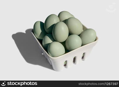 Araucana egg on basket isolated on white background. Blue or green eggs from Araucana chicken