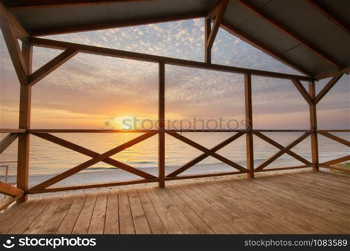 Arbour on the sea shore on the beach at sunset. Nature and indoor composition.
