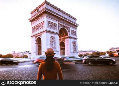 Arc de Triomphe and traveler in Paris street at night twilight