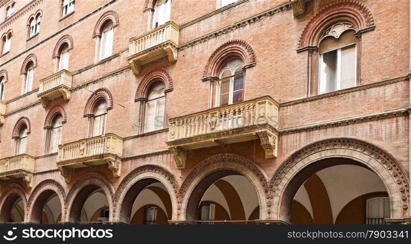 Arcade, windows and balconies on an elegant building in Bologna, Italy