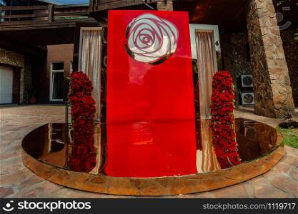 Arch for wedding ceremony a is decorated with red roses flowers and greens, greenery. wedding decor. Arch for wedding ceremony a is decorated with red roses flowers and greens, greenery. wedding decor.