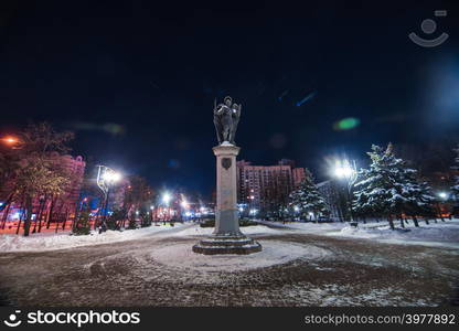 Archangel monument in snowy winter park with clean pathes