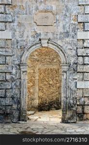 Arched gate weathered venetian belfry detail at village Louha in Zakynthos, Greece.