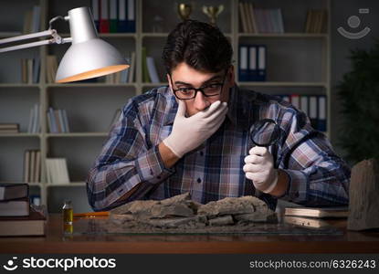 Archeologist working late night in office