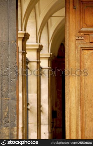 Arches seen through half open old wooden door
