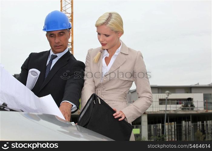 Architect and assistant visiting construction site