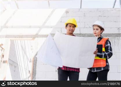 Architect and client discussing the plan with blueprint of the building at construction site. Asian engineer foreman worker man and woman working talking on drawing paper to checking project