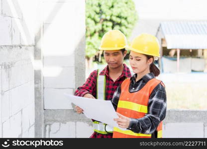 Architect and client discussing the plan with blueprint of the building at construction site. Asian engineer foreman worker man and woman working talking and checking on draw paper to checking project