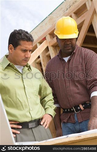 Architect and construction worker examining structure on construction site
