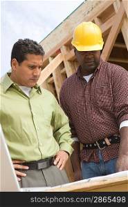 Architect and construction worker examining structure on construction site