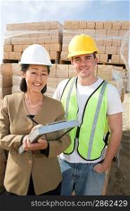 Architect and construction worker standing on construction site