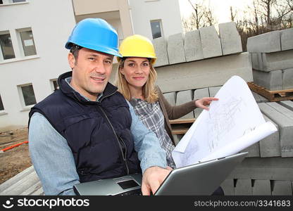 Architect and engineer looking at plan on construction site