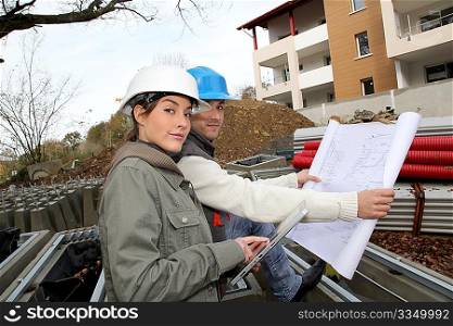 Architect and engineer looking at plan on construction site