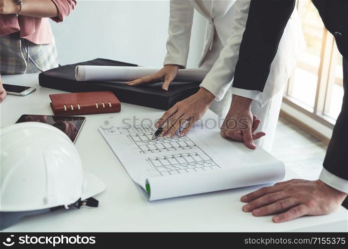 Architect and engineer working with construction drawing project on table in office. Architecture and engineering business concept.