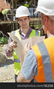 Architect Discussing Plans With Builder On Construction Site