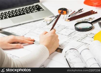 architect drawing blueprint with pencil