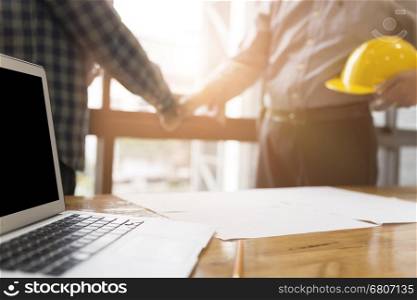 architect engineer shaking hands beside window - business teamwork, cooperation, success collaboration concept